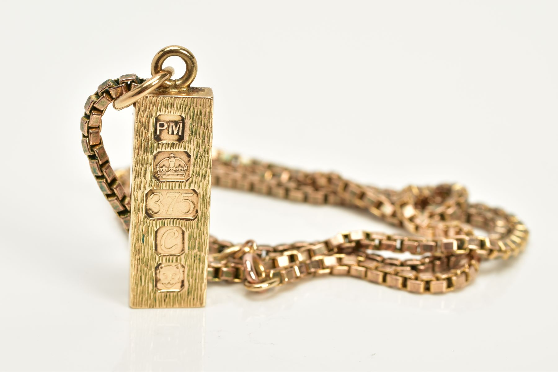 A 9CT GOLD INGOT AND CHAIN, the textured front ingot pendant, hallmarked 9ct gold London 1977,