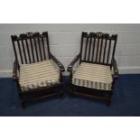 A PAIR OF EARLY TO MID 20TH CENTURY FIRESIDE OPEN ARMCHAIRS with stripped cushions (distressed)