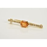 AN 18CT GOLD DIAMOND AND CITRINE BAR BROOCH, designed with a claw set oval cut Citrine, to a round