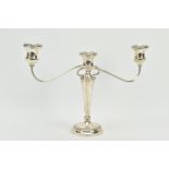 A SILVER CANDELABRA, the circular base with a textured rim design, rises to two scroll branches with