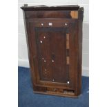 A GEORGIAN OAK AND MAHOGANY CORNER CUPBOARD with a panelled door enclosing three fixed shelves above