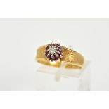 AN 18CT GOLD RUBY AND DIAMOND CLUSTER RING, designed with a central illusion set single cut diamond,