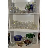 A QUANTITY OF GLASSWARE, to include four decanters, a pair of candle holders with glass shades, jars