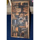 A WOODEN FRAME CONTAINING AN ASSORTMENT OF PRINTING BLOCK LETTERS, NUMBERS AND PUNCTUATION, etc,