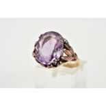 A 9CT GOLD AMETHYST RING, designed with a double claw set, oval cut amethyst, within an openwork