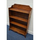 AN EARLY 20TH CENTURY MAHOGANY OPEN BOOKCASE, in the George III style, with a shaped top, two