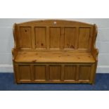 A PINE PANELLED HALL SETTLE, with a hinged storage compartnemtn, width 128cm