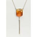 A CASED WHITE METAL AMBER PENDANT NECKLACE, the fitted pendant of square form, set with a square