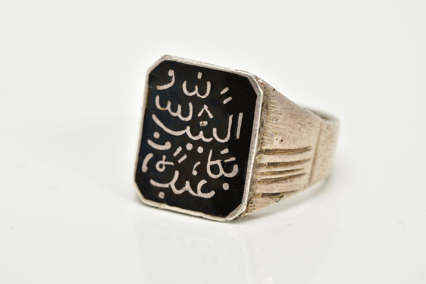 A GENTS WHITE METAL ISLAMIC SIGNET RING, designed with a rectangular Islamic inscribed black