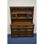 AN OLD CHARM OAK DRESSER with a central shelf to top, flanked by lead glazed cupboard doors abovve