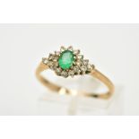 A 9CT GOLD EMERALD AND DIAMOND CLUSTER RING, designed with a central oval cut emerald, within a