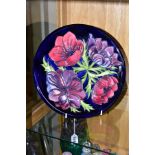 A MOORCROFT POTTERY PLATE, 'Anemone' pattern on blue ground, impressed backstamp, painted '34/94'