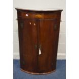 A GEORGIAN MAHOGANY AND INLAID BOWFRONT DOUBLE DOOR HANGING CORNER CUPBOARD, painted interior