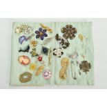 A CUSHION SLEEVE WITH COSTUME BROOCHES AND STICK PINS, to include twenty five brooches of various