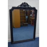A LARGE LATE 20TH CENTURY EBONISED WOOD BEVELLED EDGE OVERMANTEL MIRROR, with a foliate and scrolled