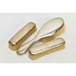 A THREE PIECE EDWARDIAN SILVER VANITY SET, to include a hair brush and two clothes brushes, each