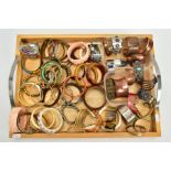 A WOODEN TRAT OF COSTUME BANGLES, a double handled wooden tray, with a quantity of costume bangles