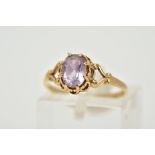 A 9CT GOLD AMETHYST RING, designed with a claw set, oval cut amethyst within an open work gallery,