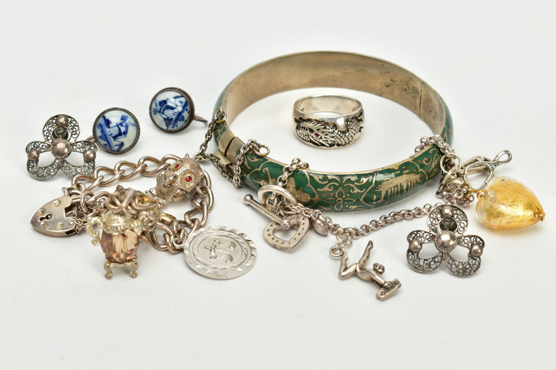 A SELECTION OF JEWELLERY, to include a silver charm bracelet, suspending four white metal charms