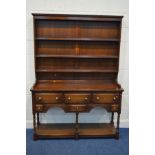 A REPRODUCTION OAK DRESSER, with a three tier plate rack above a base with six various drawers, on