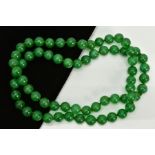 A JADE BEADED NECKLACE, dyed green circular beads, on a green cord, each bead measuring