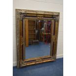 A LARGE LATE 20TH CENTURY FOLIATE GILT WOOD BEVELLED EDGE WALL MIRROR, 141cm x 173cm x depth 10cm (