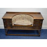 AN OLD CHARM OAK TELEPHONE TABLE/SEAT, flanked by single cupboard doors, width 118cm x depth 43cm