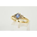 AN 18CT GOLD SAPPHIRE AND DIAMOND CLUSTER RING, designed with a central oval cut blue sapphire