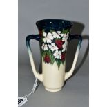 A MOORCROFT POTTERY TWIN HANDLED VASE, 'Christmas Cheer' pattern (white flowers and red berries),