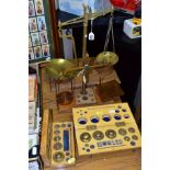TWO SETS OF BEAM SCALES, an unmarked brass set mounted on wooden base (with five assorted weights)
