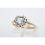 A 9CT GOLD TOPAZ CLUSTER RING, designed with a central heart cut blue topaz, within a circular cut