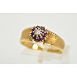 AN 18CT GOLD RUBY AND DIAMOND CLUSTER RING, designed with a central illusion set single cut diamond,