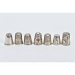 SEVEN THIMBLES, to include a plain polished thimble, hallmarked Birmingham, a floral engraved