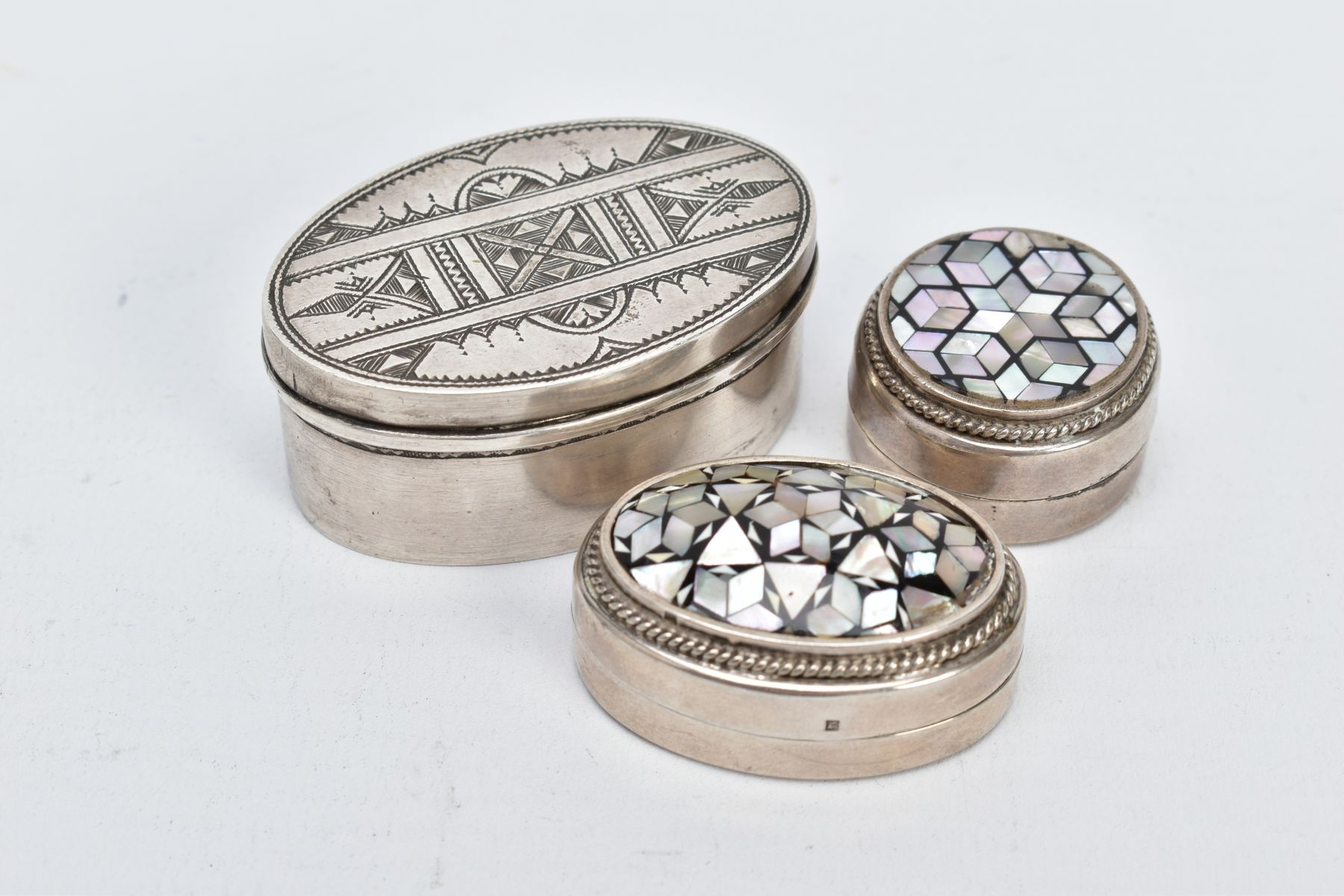 TWO EGYPTIAN SILVER PILL BOXES AND A WHITE METAL TRINKET BOX, two pill boxes of a circular and