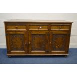 A MID TO LATE 20TH CENTURY OAK SIDEBOARD, with three drawers above triple carved panel cupboard