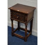 A REPRODUCTION OAK LAMP TABLE, single drawer with a stylised front, on cylindrical tapering front