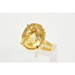 A YELLOW METAL CITRINE RING, designed with a claw set oval cut Citrine, openwork basket designed