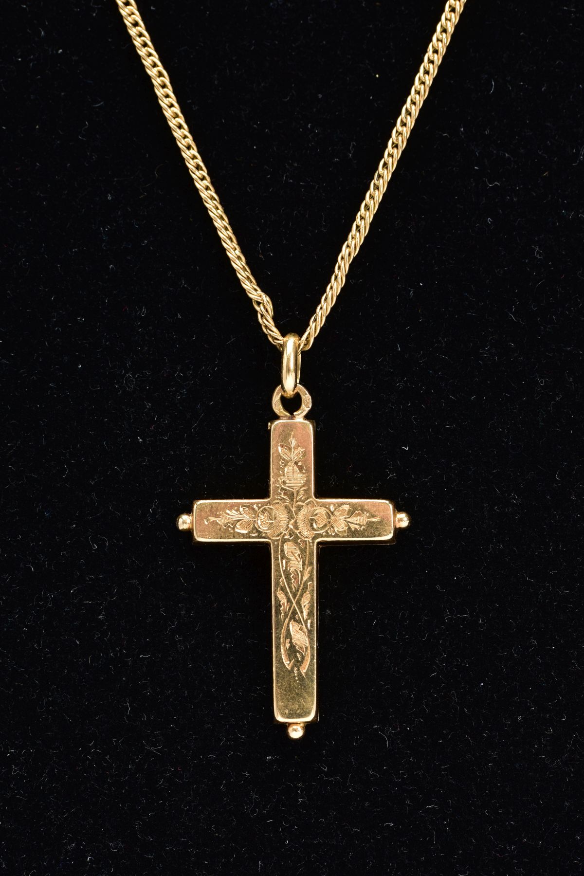 AN 18CT GOLD CRUCIFIX LOCKET AND CHAIN, the foliate and scroll engraved hinged pendant, opens to