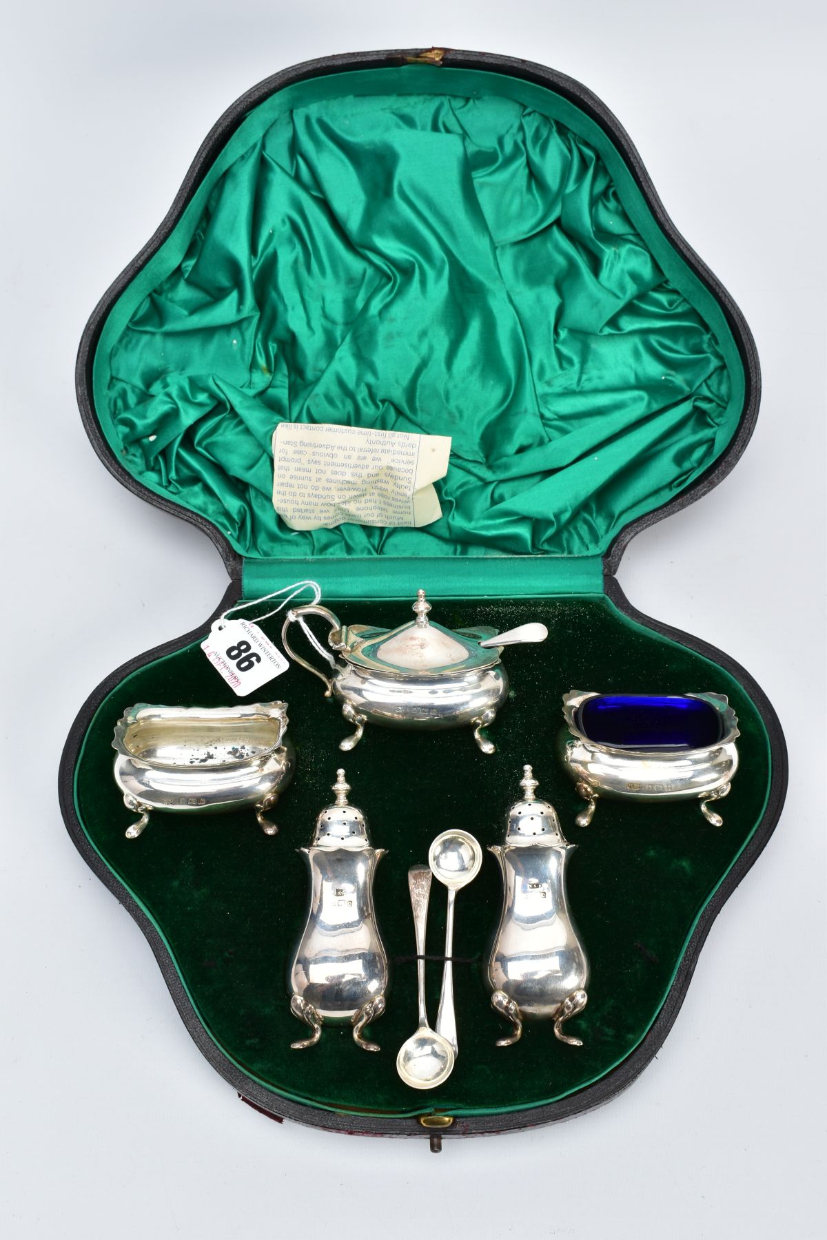 A SILVER EDWARDIAN CASED CONDIMENT SET, to include two salts (one with blue glass insert), a mustard