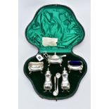 A SILVER EDWARDIAN CASED CONDIMENT SET, to include two salts (one with blue glass insert), a mustard