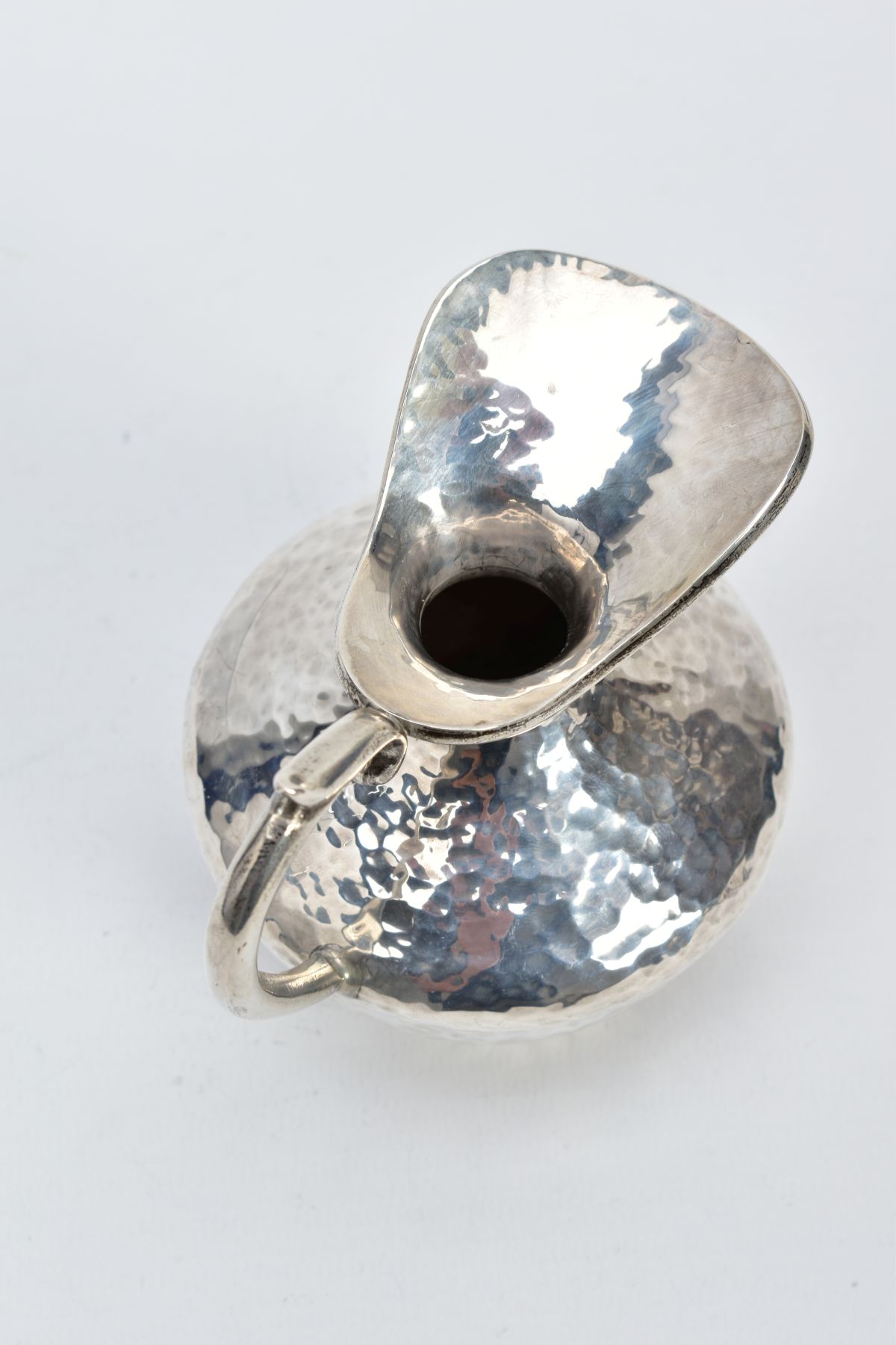 A WHITE METAL JUG, of a hammered design, scroll handle, stamped 925 to the base, approximate gross - Image 4 of 5