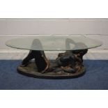 AN EXPLICIT RESIN GLASS TOP COFFEE TABLE, on a semi clad woman (sd to resin)