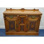 AN EDWARDIAN WALNUT SIDEBOARD, elaborately carved stylised drawer fronts and fielded panels, with