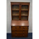 A VICTORIAN PITCH PINE BUREAU BOOKCASE, the top with glazed double doors enclosing two fixed