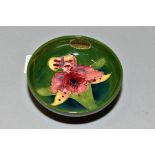 A SMALL MOORCROFT POTTERY FOOTED BOWL, 'Orchid' pattern on green ground, impressed backstamp and