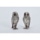 A PAIR OF SILVER SALT AND PEPPER POTS, each in the form of an owl, realistically modelled standing