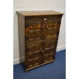 A REPRODUCTION OAK FOUR DOOR CUPBOARD, in the Jacobean style, each door with fielded panels, and