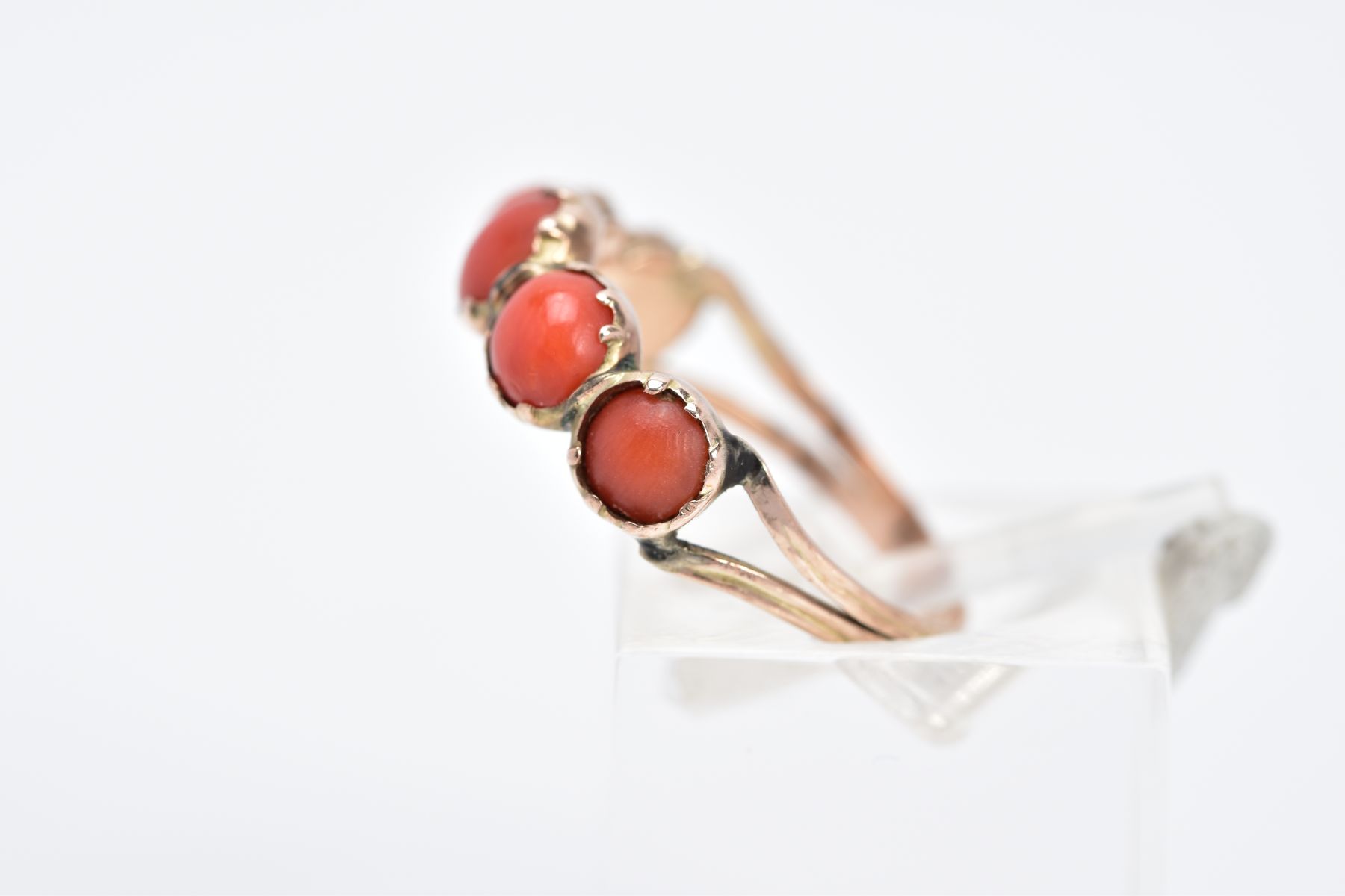 A YELLOW METAL CORAL RING, designed with five graduated coral cabochons, bifurcated textured - Image 2 of 3