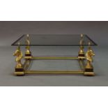 A modern brass and glass coffee table, c.1970, the square glass top on brass horsehead supports,