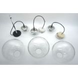 A set of three Dutch Raak pendant lights, 20th century, each with globular clear glass shades, the